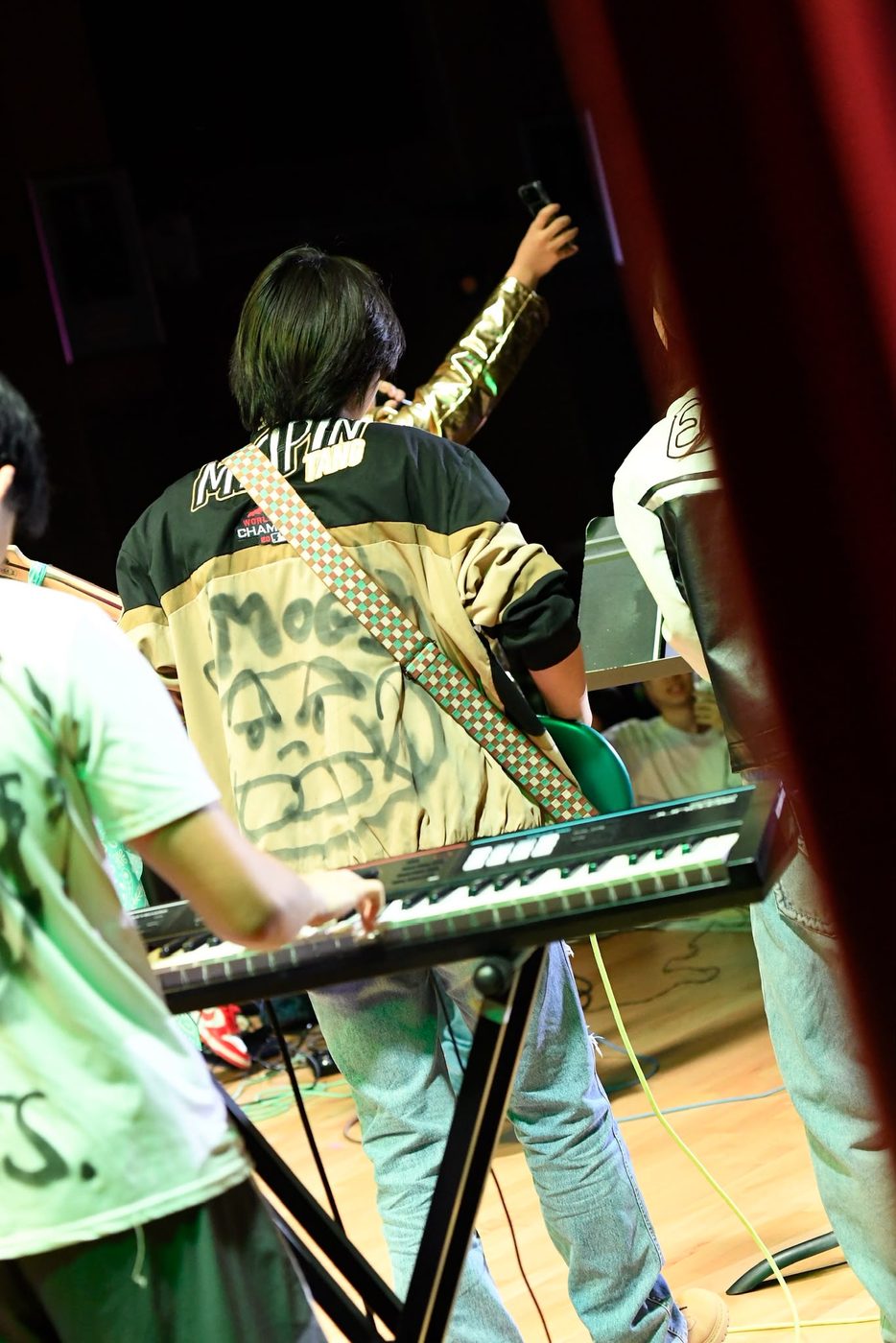 Varsity jacket sprayed with the MOGI face, worn on stage